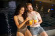 © BGStock72 - Young couple relaxing and drinking fresh orange juice on the poolside