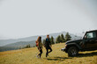 © BGStock72 - Smiling couple walking with backpacks over green hills