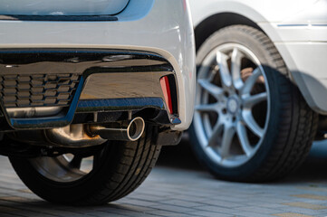 Wall Mural - closeup of the wheels and bumpers of a car parked in the yard of a residential house, lower section