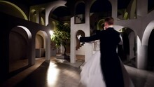Happy Just Married Couple Is Dancing Waltz In Ballroom Of Amazing Palace In Night, Romantic Dance