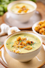 Wall Mural - Garlic cream soup with bread croutons in rustic bowl