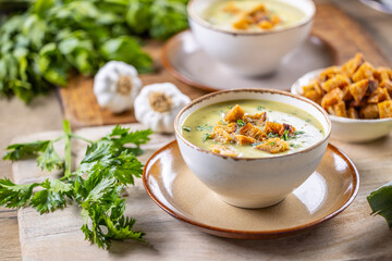 Wall Mural - Garlic cream soup with bread croutons and flavored with copped celery leaves