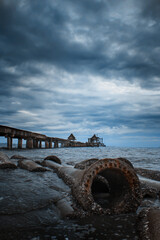 Abandoned Thai church among sea in cloudy day, Pattaya, Broken metal pipe under water nearby the beach