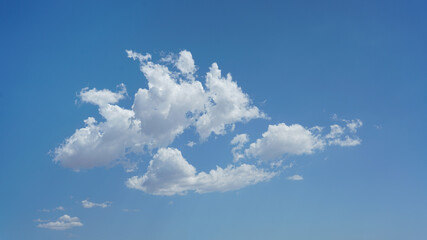 Wall Mural - isolated puffy clouds and blue sky for background use or sky substitution
