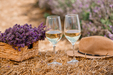 Two Glasses of white wine in a lavender field in Provance. Violet flowers on the background