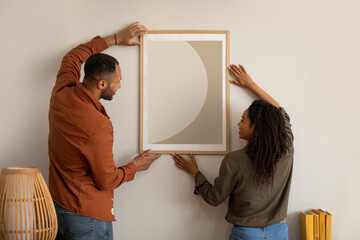 Wall Mural - African American Couple Hanging Poster On Wall At Home