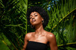 African american model tropical fashion portrait  . Beautiful woman posing  against green exotixc palms trees.