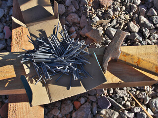 Antique hammer and a box of nails on a construction site. Selective focus.