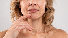 Closeup Of Middle Aged Woman With Nasolabial Folds Touching Face With Finger