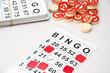 © iama_sing - Many wooden chips with numbers and cards for a board game of bingo or lotto on a light background.