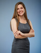 © Yuriy Shevtsov - Happy business woman with long hair in gray dress standing with arms crossed. Isolated portrait.