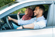 © Prostock-studio - Glad smiling millennial islamic husband driving at steering wheel with wife in hijab, ride in car, enjoy music
