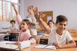 © JackF - Friendly schoolchildren raise their hand to answer during the lesson