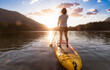 © edb3_16 - Adventurous Woman Paddling on a Paddle Board in a peaceful lake. Colorful Sunset Art Render. Hicks Lake, Sasquatch Provincial Park near Harrison Hot Springs, British Columbia, Canada.