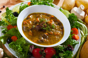 Sticker - Delicious cooked goulash from chicken hearts served with vegetables and fresh lettuce at plate..