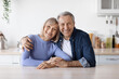 Portrait of happy loving senior couple posing together at kitchen