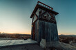Abandoned wood and steel lookout tower in the desert at sunset