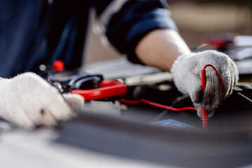 Canvas Print - Automotive mechanics repairman use digital voltage multimeter to check voltage level in car battery, check the mileage of the car, auto maintenance service concept.