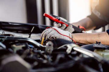 Canvas Print - Automotive mechanics repairman use digital voltage multimeter to check voltage level in car battery, check the mileage of the car, auto maintenance service concept.