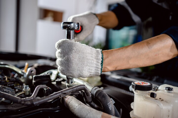 Wall Mural - close up of view Auto mechanic repairman using a socket wrench working engine repair in the garage, change spare part, check the mileage of the car, checking and maintenance service concept.