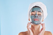 © Deen Jacobs/peopleimages.com - Facial, skincare and woman with face mask cream for beauty, health and wellness in studio with blue background. Cosmetics, product and young girl at luxury spa for acne treatment in a model portrait