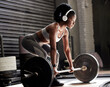 © Ami-Lou W/peopleimages.com - Power, fitness and headphones of a woman with barbell weight lift exercise, workout or training in wellness gym. Sports black woman listening to motivation music for muscle, strength and health