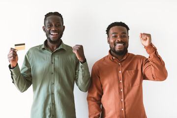 Wall Mural - Two African Guys Holding Credit Card Gesturing Yes, White Background