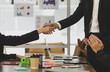 © Bangkok Click Studio - Closeup shot of handshaking of unrecognizable unknown male businessman and female businesswoman in meeting room after business agreement deal done while colleagues clapping hands celebrating together
