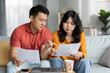 © Prostock-studio - Confused asian spouses checking bills, home interior