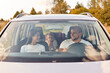 Family, transport, safety, road trip. Portrait of happy man and woman with little child in baby seat driving in car, expressing positive emotions, traveling together, smiling.