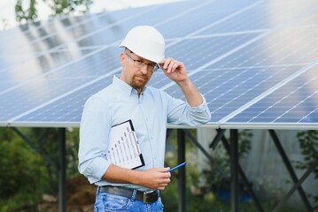 Engineer at solar power station with solar panel. Practical lessons on renewable energy power plants.