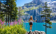 Woman looks at beautiful turquoise lake in the mountain ( oeschinensee in Switzerland)