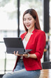 © David - Business Asian Female holding tablet laptop and steanding in the workplace, concept of business accounting documents planning finance analysis and report,