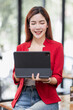 © David - Business Asian Female holding tablet laptop and steanding in the workplace, concept of business accounting documents planning finance analysis and report,