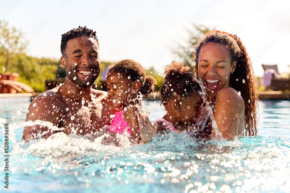 Family On Summer Holiday With Two Girls Being Held In Swimming Pool By ...