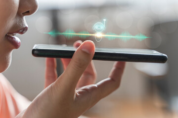 close up of pretty woman holding in hand smart phone talking with digital assistant or friend distan
