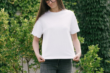 Wall Mural - Woman wearing white t-shirt with space for logo or design in the park in summer