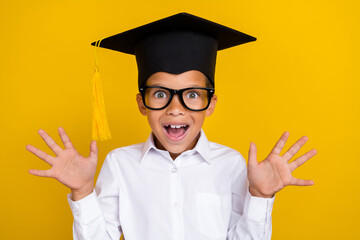 Wall Mural - portrait of surprised astonished boy raise opened hands unbelievable isolated on yellow color backgr