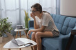 © StockPhotoPro - Woman sitting on the sofa and connecting with her laptop