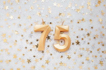 Wall Mural - Number 75 seventy five golden celebration birthday candle on Festive Background. seventy five years birthday. concept of celebrating birthday, anniversary, important date, holiday