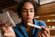 © Drobot Dean - Young black woman holding pregnancy test and instruction at home