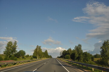 asphalt road, car trip view from the window around the field green grass beautiful sky