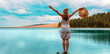 woman arms raised enjoying beautiful turquoise lake