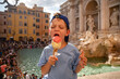 Cute cheerful boy 7 years old eating ice cream (gelato) near the Trevi Fountain in Rome, Italy.