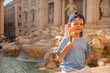 Cute cheerful boy 7 years old eating ice cream (gelato) near the Trevi Fountain in Rome, Italy.