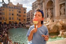 Cute Cheerful Boy 7 Years Old Eating Ice Cream (gelato) Near The Trevi Fountain In Rome, Italy.