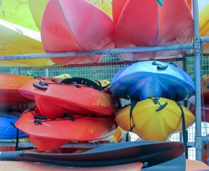 Poster - canoes of different colors stacked in the harbor