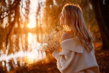 Wall Mural - Portrait of young blonde girl holding flowers in autumn park