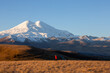 A small figure of a man against the backdrop of a large-scale large snowy mountain. Elbrus, morning.