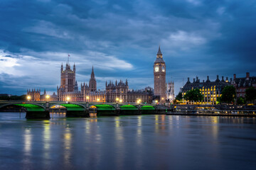 Wall Mural - View of Westminster palace and bridge over river Thames with Big Ben illuminated at night in London, UK